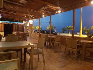 ein Restaurant mit Tischen und Stühlen und Blick auf das Meer in der Unterkunft Hotel Ionion in Kyllini