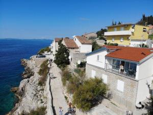 a group of buildings on a cliff next to the water at Apartment Svemir in Primošten