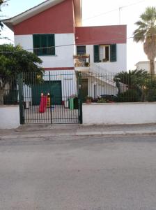 una casa bianca e rossa con un cancello nero di Villa Margherita a Mazara del Vallo
