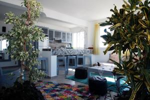 a kitchen with white cabinets and plants in a room at Résidence papillon bleu in Tamraght Ouzdar
