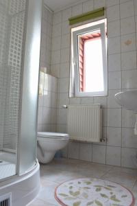 a bathroom with a toilet and a sink and a window at Center Angelos in Bronków