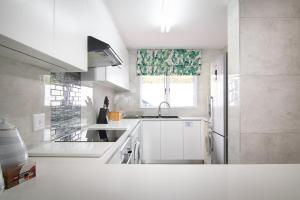 a white kitchen with a sink and a window at Le Paradis 23 in Ballito