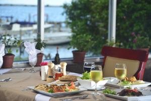 a table with plates of food and glasses of wine at Ramada by Wyndham Princess Belize City in Belize City +41 photos