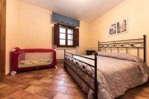 um quarto com uma cama e um berço em Casa Sirio em Palaia