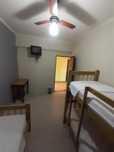 Cette chambre comprend 2 lits superposés et un ventilateur de plafond. dans l'établissement Hotel & Hostel San José, à Ribeirão Preto