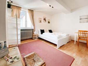 sala de estar con cama blanca y alfombra roja en Apollo Apartments, en Núremberg