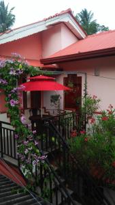 ティッサマハーラーマにあるTissa Rainbow Guest & Yalaのテーブルと赤傘付きの家