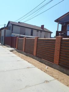 a wooden fence in front of a house at Дом у моря in Zatoka