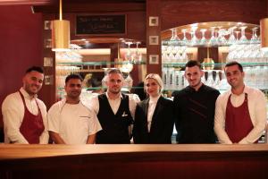 a group of people standing behind a bar at NOEL Hotel-Restaurant in Seevetal