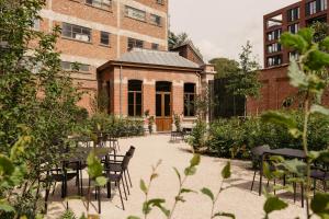 a courtyard with tables and chairs in front of a building at august in Antwerp