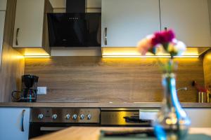 a vase of flowers sitting on a table in a kitchen at Apart Sporer in Hippach +5 photos