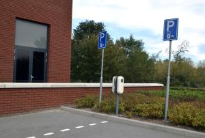 three blue parking signs in front of a brick building at Bastion Hotel Eindhoven Waalre in Eindhoven