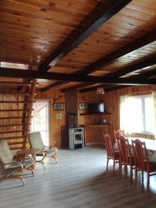 sala de estar con techos de madera, mesa y sillas en Center Angelos en Bronków