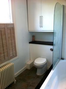 a small bathroom with a toilet and a glass shower at Arsenal 123 in London