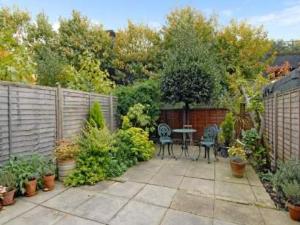 a patio with two chairs and a table in a garden at Arsenal 123 in London