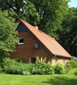 a small brick house with a red roof at Ferienhof Heimberg - Bowe GbR in Sauensiek
