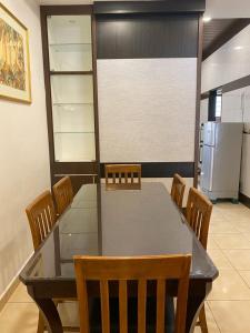 a dining room with a table and chairs and a refrigerator at HILLVIEW HOMESTAY in Tanah Rata