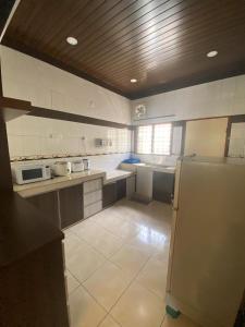 a large kitchen with a refrigerator and a stove at HILLVIEW HOMESTAY in Tanah Rata