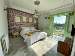 Un dormitorio con una cama y una ventana grande. en Dar El Kif - La Marsa, en La Marsa