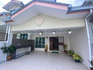 ein weißes Haus mit Pflanzen im Innenhof in der Unterkunft HILLVIEW HOMESTAY in Tanah Rata