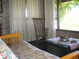 sala de estar con mesa y mecedora en Cabaña Maya en Sierra de los Padres