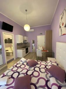 a bedroom with a large bed with purple walls at al Corso 203 in Salerno