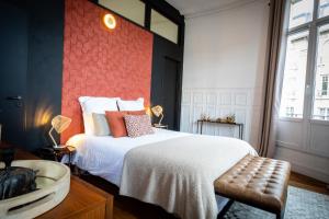 een slaapkamer met een bed met een rode bakstenen muur bij L’Aristide in Reims