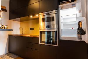 - une cuisine avec des appareils en acier inoxydable et une bouteille de vin dans l'établissement L’Aristide, à Reims 23 autres photos