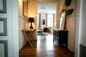 - un couloir d'une maison avec une table et un miroir dans l'établissement L’Aristide, à Reims