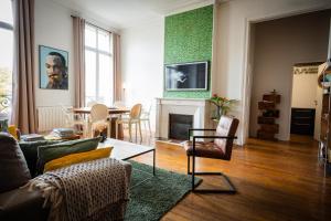 a living room with a couch and a fireplace at L’Aristide in Reims