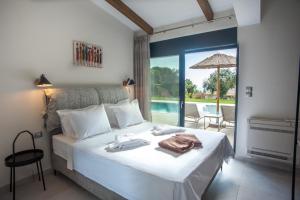 a bedroom with a bed with a view of a pool at Premium Ionian Villas - Vlachata in Vlachata +98 photos