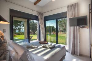 a bedroom with a bed with a large window at Premium Ionian Villas - Vlachata in Vlachata