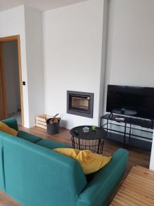 sala de estar con sofá azul y TV en Párpados, casa con jacuzzi para dos, en Mélida