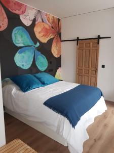 a bedroom with a bed with a painting of butterflies at Párpados, casa con jacuzzi para dos in Mélida