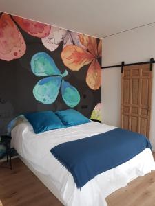 a bedroom with a bed with a painting of butterflies at Párpados, casa con jacuzzi para dos in Mélida