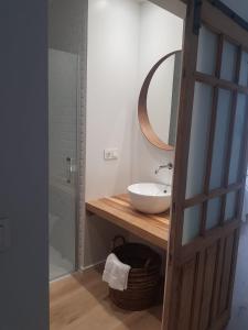 uma casa de banho com um lavatório e um espelho em Dos Alas Rojas, casa con jacuzzi para dos personas em Mélida