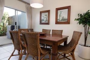 a dining room with a wooden table and chairs at Crayfish 10 in Ballito
