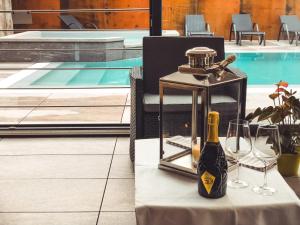 a bottle of wine and glasses on a table next to a pool at Residence Lake Como in Colico