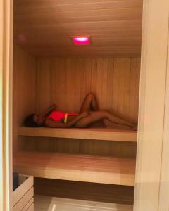 a man is laying in a sauna at Residence Lake Como in Colico