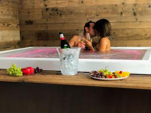 a man and woman in a hot tub with a kiss at Residence Lake Como in Colico