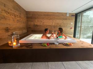 two people sitting in a bath tub with a candle at Residence Lake Como in Colico