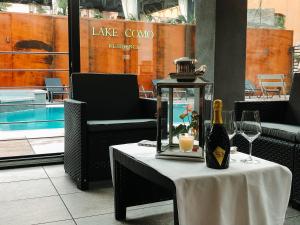 a table with a bottle of wine and glasses on it at Residence Lake Como in Colico