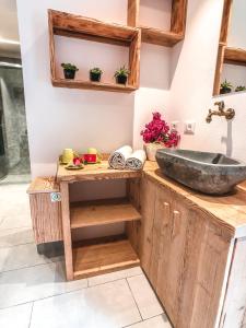 a bathroom with a stone sink on a wooden counter at Residence Lake Como in Colico