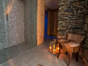 a bathroom with a glass shower and a chair and a lamp at Residence Lake Como in Colico