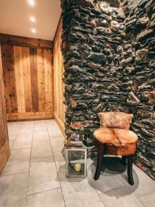 a room with a chair and a stone wall at Residence Lake Como in Colico