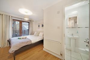 a bedroom with a bed and a bathroom with a sink at 2 Bed Chic Apartment near Shoreditch & Liverpool St FREE WIFI & PARKING by City Stay Aparts London in London