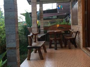 a patio with wooden chairs and a table and a piano at บ้านศรีสมบูรณ์ เชียงคาน in Chiang Khan