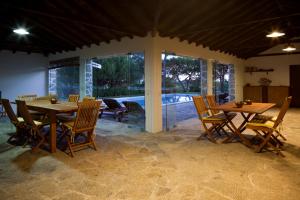 a dining room with wooden tables and chairs and a pool at Solar Do Magoito in Sintra