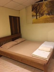 two beds in a room with a picture on the wall at บ้านศรีสมบูรณ์ เชียงคาน in Chiang Khan