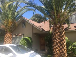 a car parked in front of a house with palm trees at habitaciones exclusivas in Curicó
